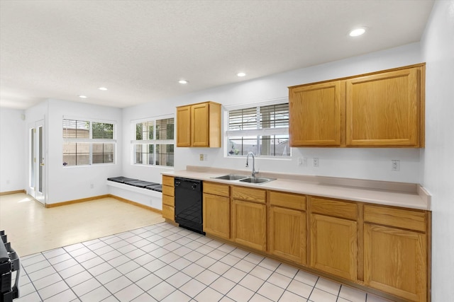 kitchen featuring light countertops, black dishwasher, recessed lighting, and a sink