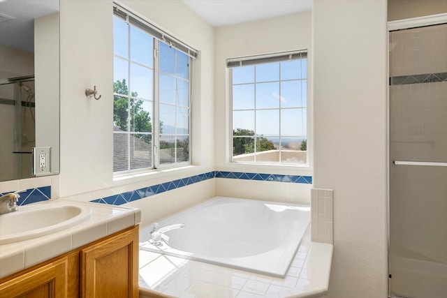 bathroom featuring a stall shower, vanity, and a bath