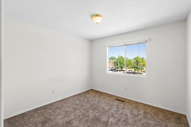 carpeted empty room featuring visible vents, baseboards, and a textured ceiling