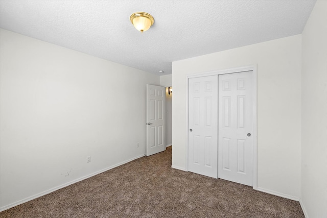 unfurnished bedroom with baseboards, carpet, a closet, and a textured ceiling