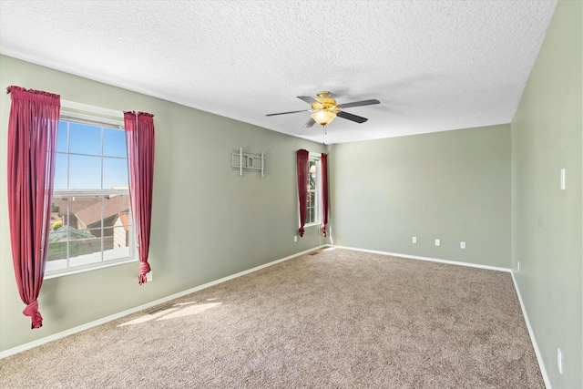 empty room featuring a textured ceiling, baseboards, carpet floors, and ceiling fan