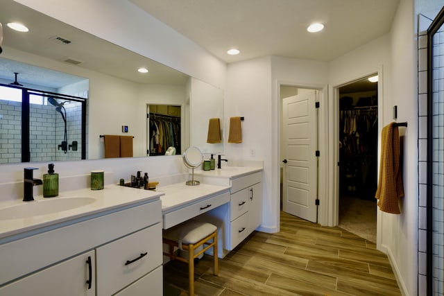 bathroom with a stall shower, visible vents, wood tiled floor, vanity, and recessed lighting