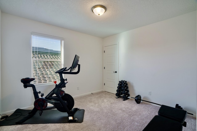 workout room featuring carpet flooring, a textured ceiling, and baseboards