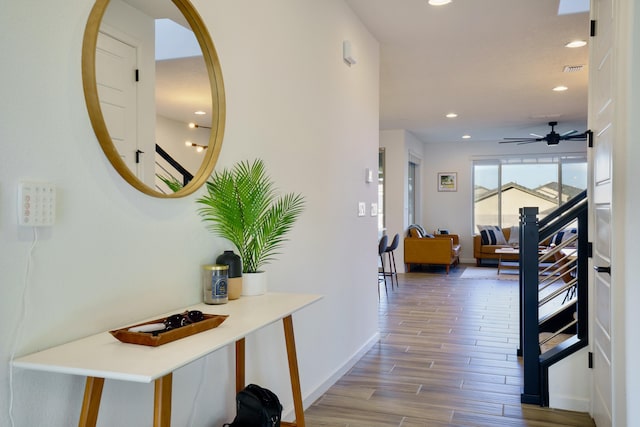 hall featuring recessed lighting, baseboards, and wood finished floors