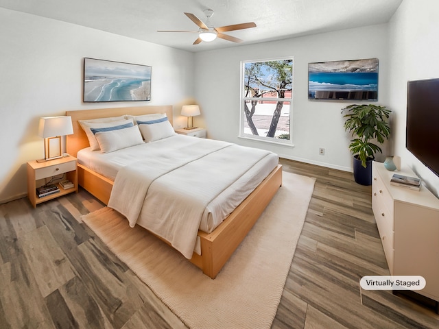 bedroom featuring a ceiling fan, baseboards, and wood finished floors