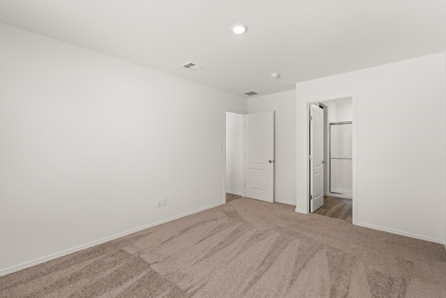 unfurnished bedroom featuring visible vents, baseboards, carpet, and ensuite bathroom