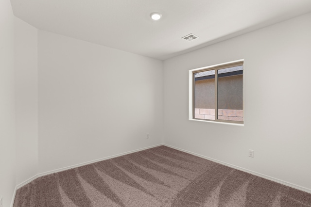 carpeted empty room with visible vents and baseboards