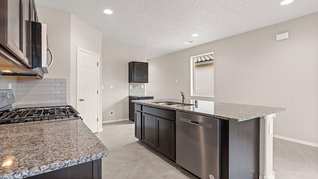 kitchen with a kitchen island with sink, a sink, light stone counters, range with gas stovetop, and dishwasher