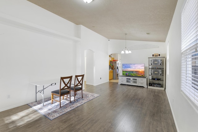 dining room featuring baseboards, arched walkways, lofted ceiling, dark wood-style flooring, and an inviting chandelier