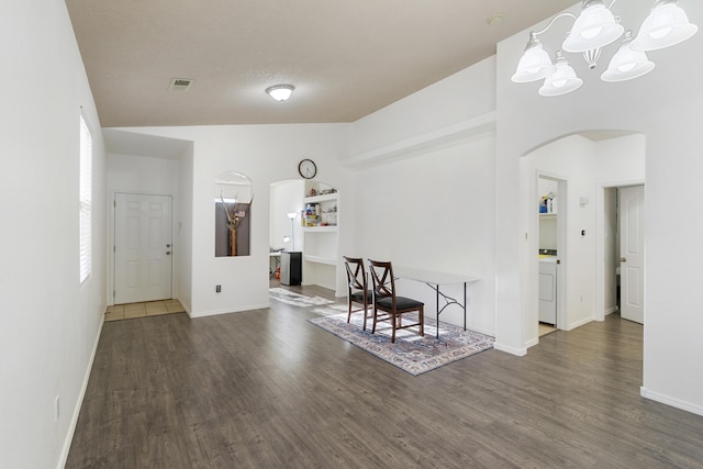 entrance foyer featuring arched walkways, washer / clothes dryer, visible vents, and wood finished floors