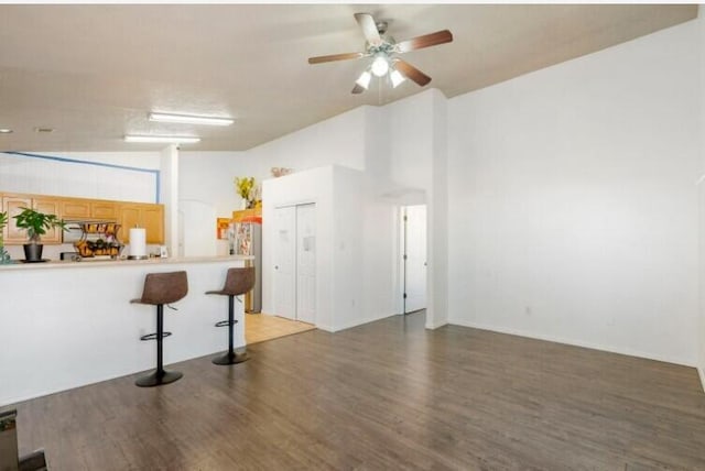 interior space featuring light wood-type flooring, a high ceiling, and a ceiling fan