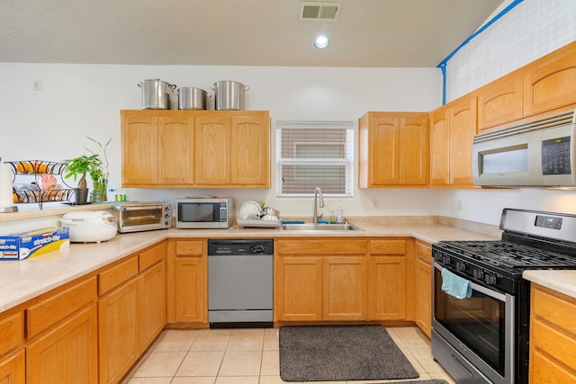 kitchen featuring light tile patterned floors, a toaster, visible vents, stainless steel appliances, and a sink