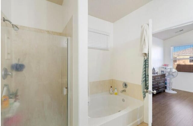 full bathroom featuring lofted ceiling, a stall shower, wood finished floors, and a bath