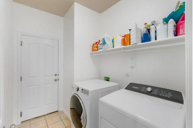 washroom featuring laundry area, light tile patterned floors, and separate washer and dryer