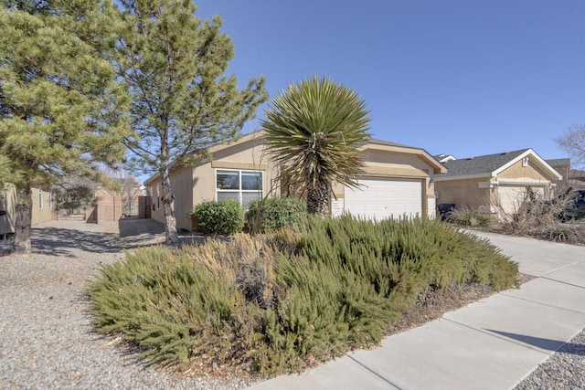 view of front of home with stucco siding, an attached garage, and concrete driveway