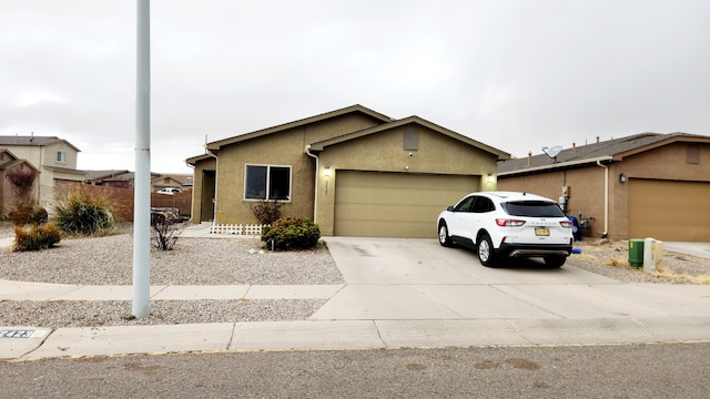 view of front facade featuring concrete driveway, a garage, and stucco siding