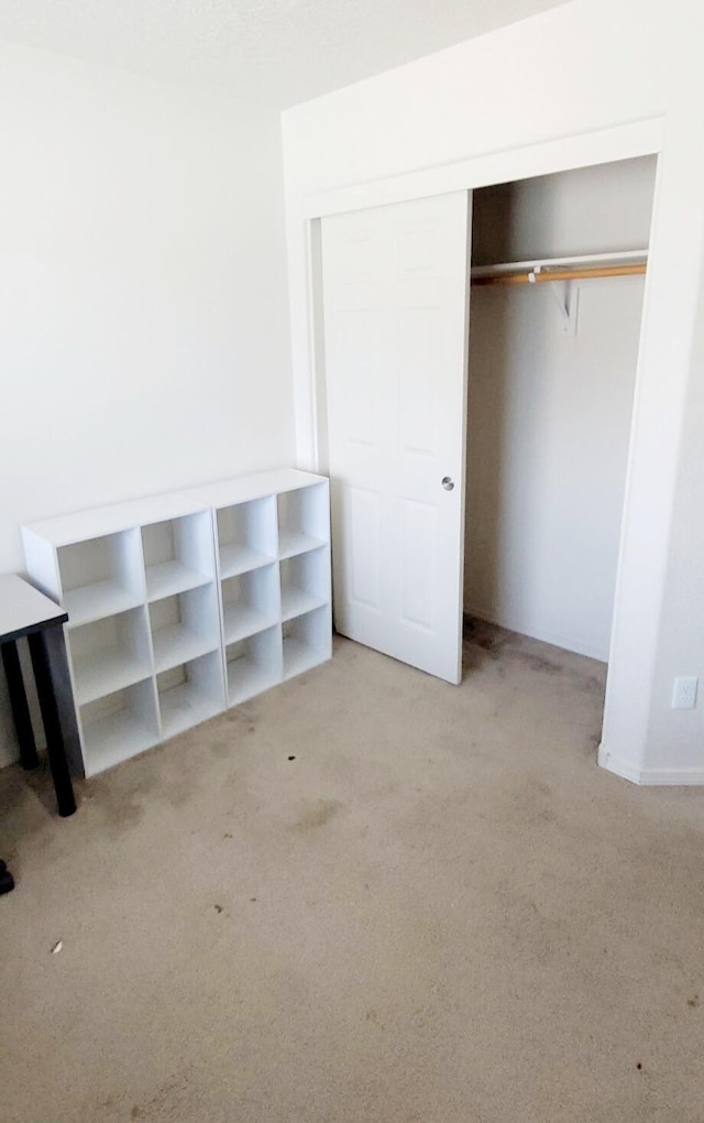 unfurnished bedroom featuring carpet and a closet