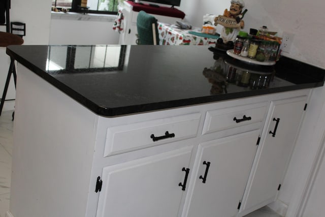 kitchen with dark countertops and white cabinets