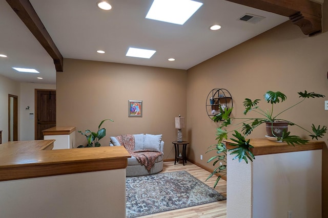 interior space with visible vents, baseboards, light wood-type flooring, recessed lighting, and a skylight