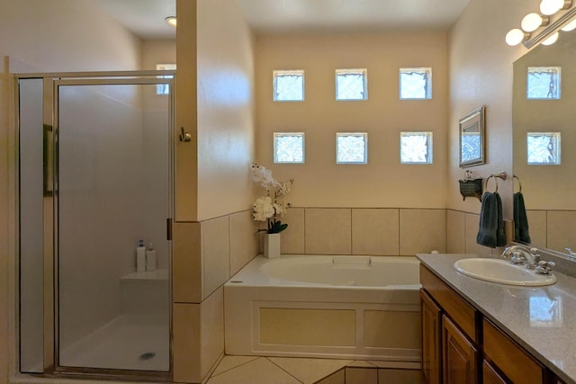 full bath featuring tile patterned flooring, plenty of natural light, a stall shower, and a garden tub