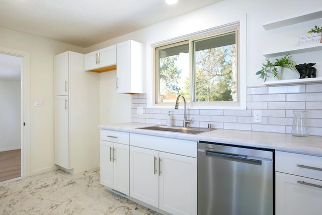 kitchen featuring a sink, open shelves, stainless steel dishwasher, white cabinetry, and decorative backsplash