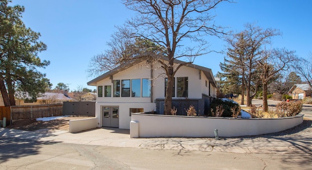 back of house with stucco siding, fence private yard, and french doors