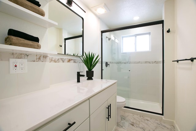 full bathroom featuring vanity, baseboards, a stall shower, toilet, and marble finish floor