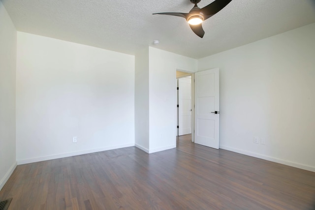 empty room with ceiling fan, baseboards, a textured ceiling, and dark wood finished floors