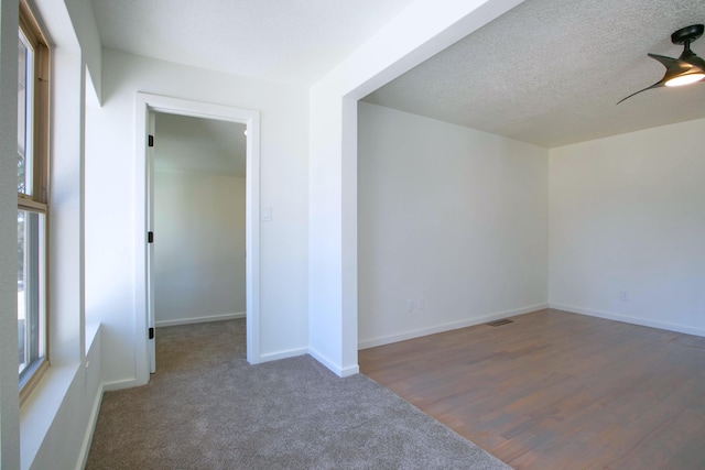 unfurnished room with ceiling fan, baseboards, carpet floors, and a textured ceiling