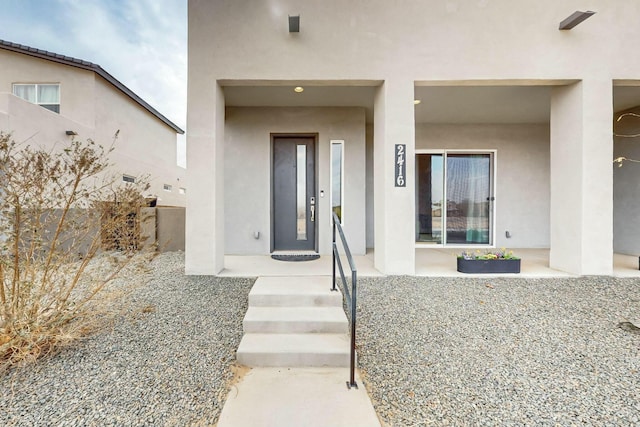 doorway to property featuring elevator and stucco siding