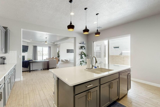 kitchen with dishwasher, wood tiled floor, visible vents, and a sink