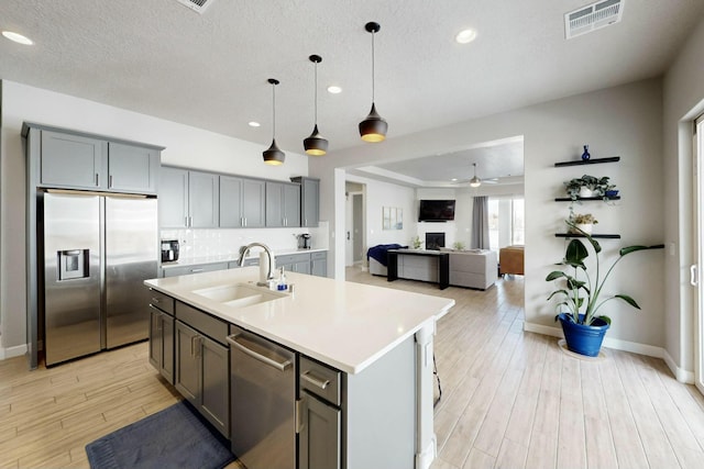 kitchen with visible vents, stainless steel appliances, light countertops, and a sink