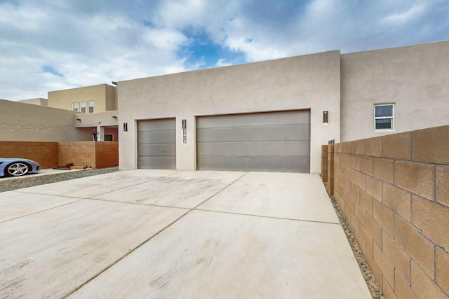 garage with driveway and fence