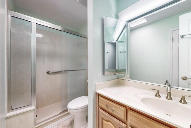 bathroom featuring a stall shower, vanity, toilet, and tile patterned floors