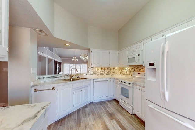 kitchen featuring visible vents, decorative backsplash, white cabinetry, a sink, and white appliances