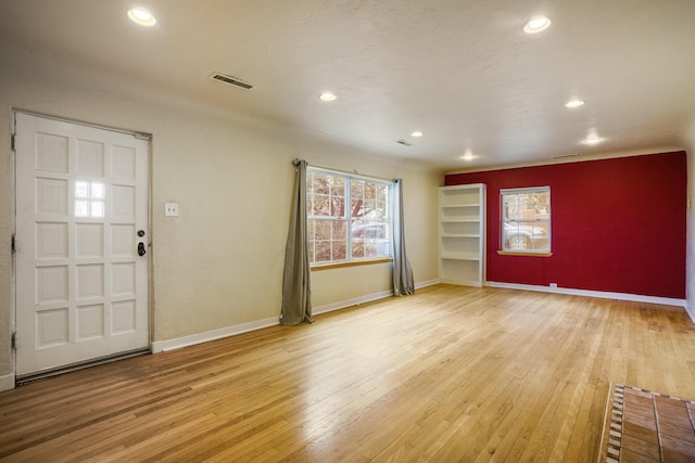 entrance foyer featuring wood-type flooring, visible vents, and baseboards