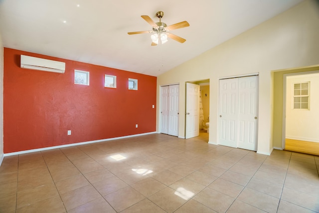 unfurnished bedroom featuring a wall mounted AC, light tile patterned flooring, two closets, and baseboards