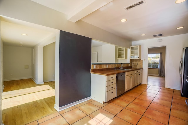 kitchen featuring light tile patterned floors, stainless steel appliances, backsplash, and visible vents