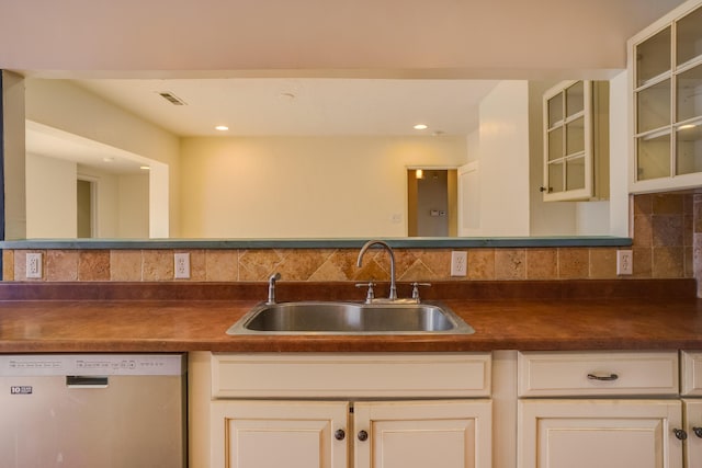 kitchen with a sink, backsplash, dishwasher, dark countertops, and glass insert cabinets