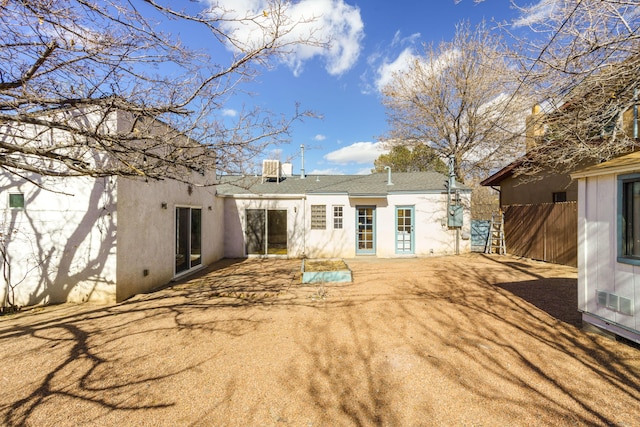 back of property featuring stucco siding, fence, and a patio