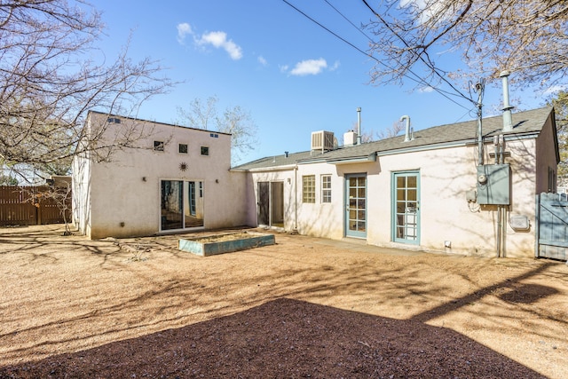 back of property featuring central air condition unit, fence, and stucco siding