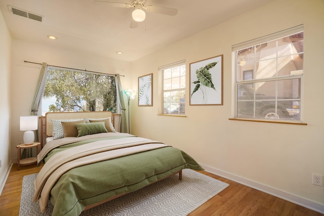 bedroom with recessed lighting, wood finished floors, visible vents, and baseboards