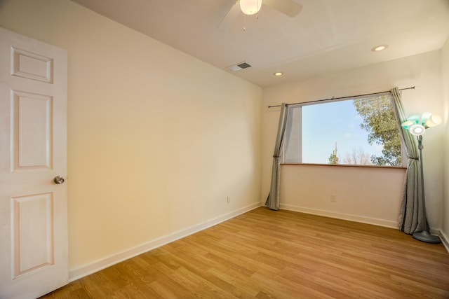 unfurnished room featuring light wood-style flooring, visible vents, and baseboards