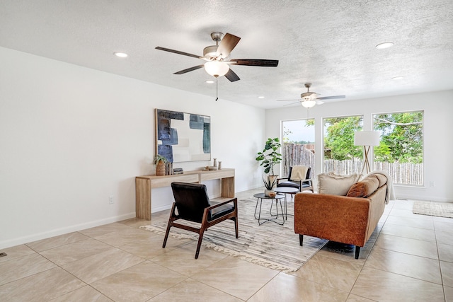 sitting room featuring a textured ceiling, light tile patterned floors, recessed lighting, and baseboards