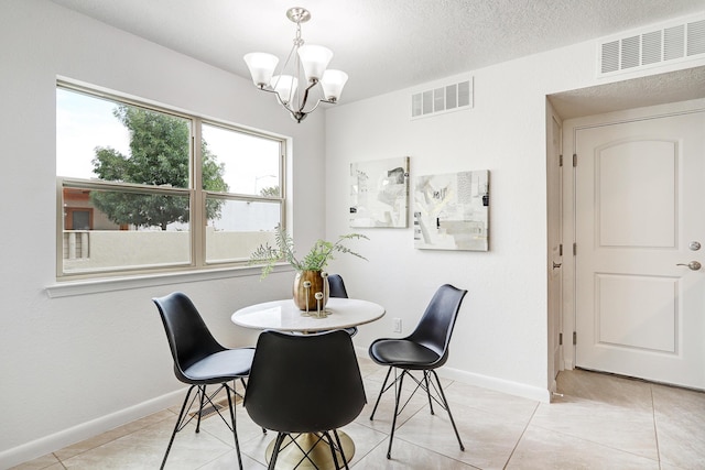 dining space featuring baseboards, visible vents, a textured ceiling, and light tile patterned flooring