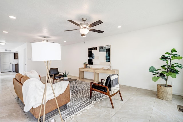 living area featuring light tile patterned floors, visible vents, a ceiling fan, a textured ceiling, and recessed lighting