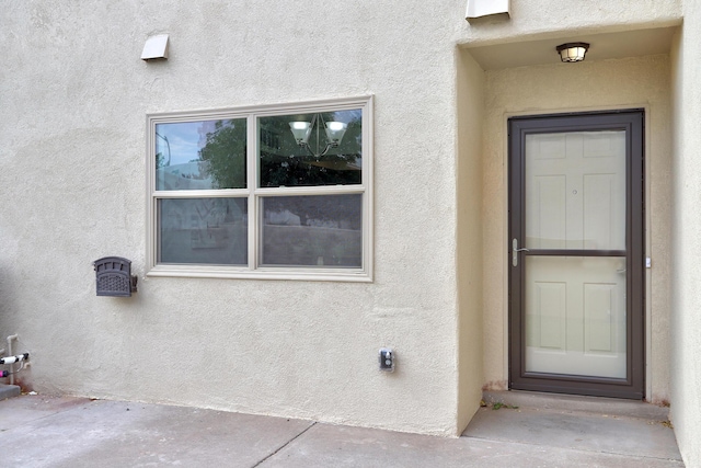 entrance to property with stucco siding