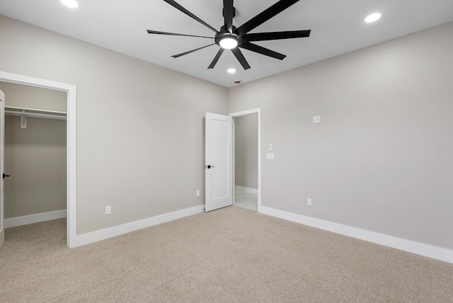 unfurnished bedroom with recessed lighting, light carpet, and a spacious closet