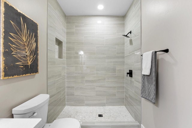 bathroom with toilet and a tile shower