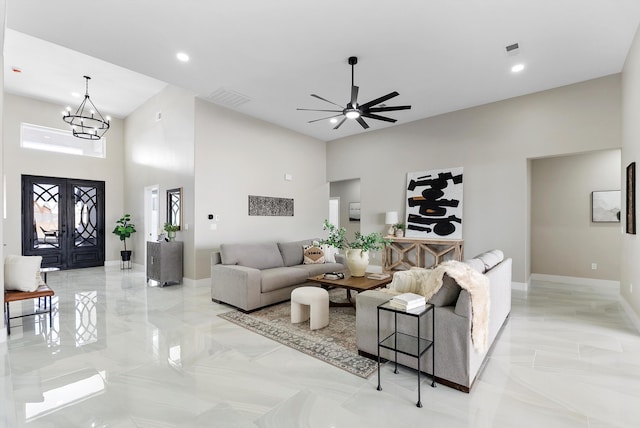 living room with marble finish floor, visible vents, baseboards, and ceiling fan with notable chandelier